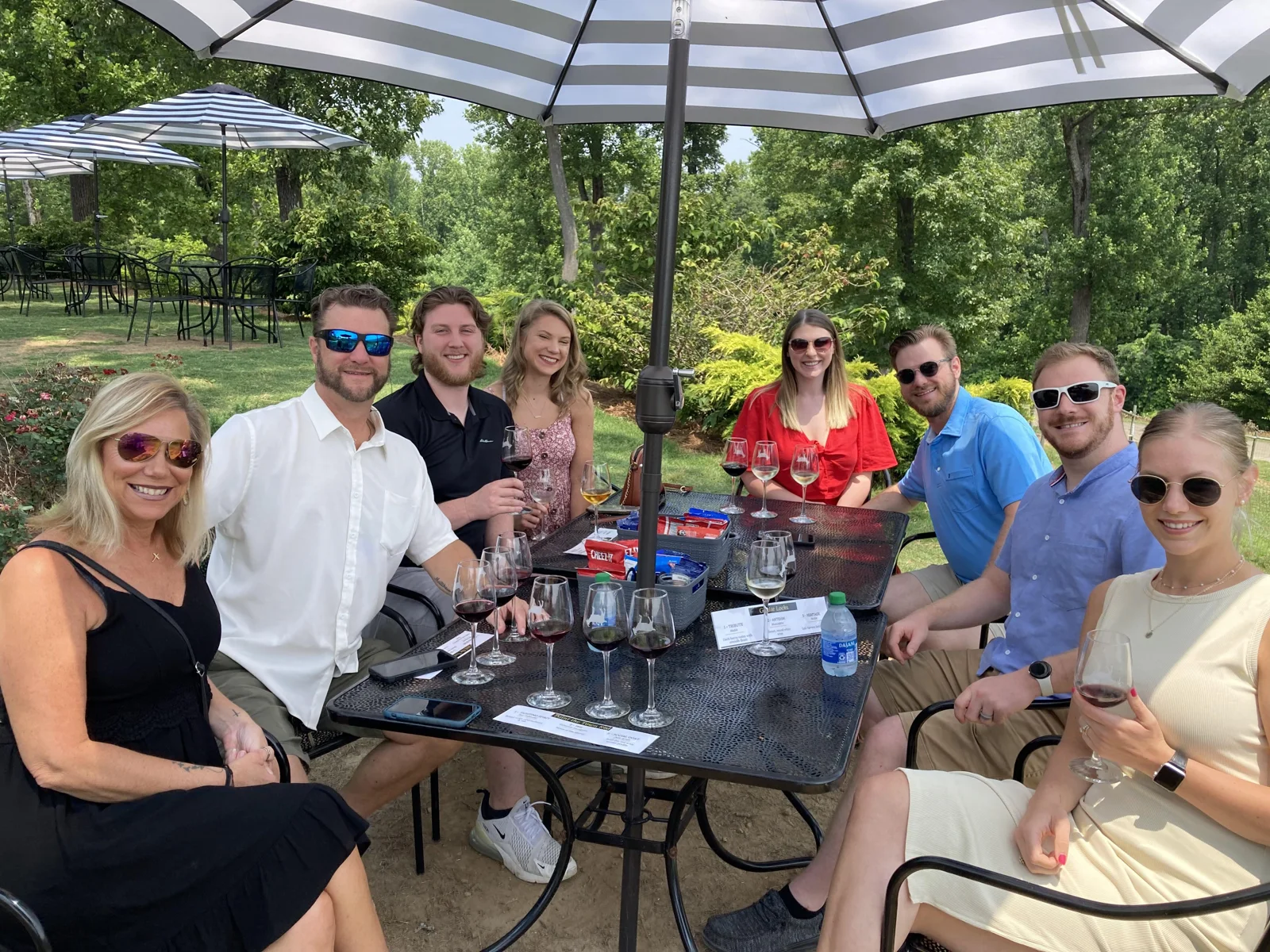 A tour group enjoying wine together at an outdoor patio table
