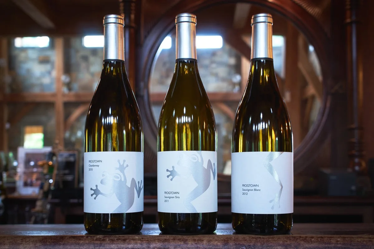 Three Frogtown wine bottles inside the winery