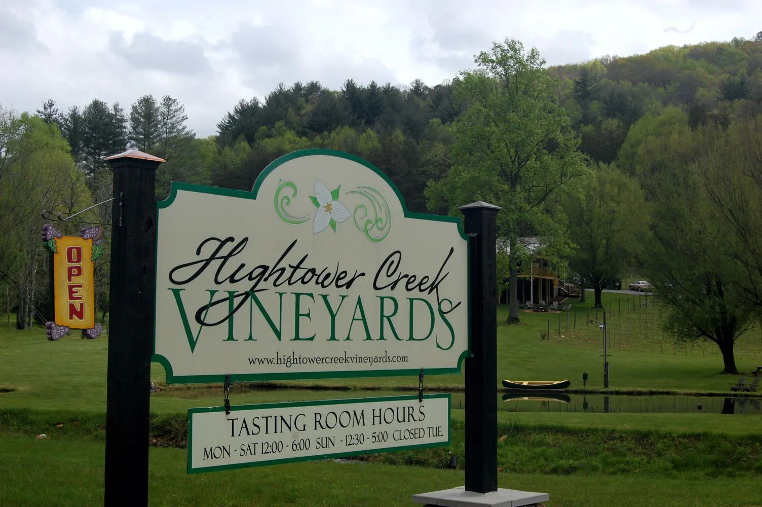 Hightower Creek Vineyards entrance sign with vines and wooded hills