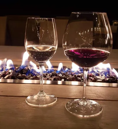 Wine glasses beside an outdoor fire table at Trillium